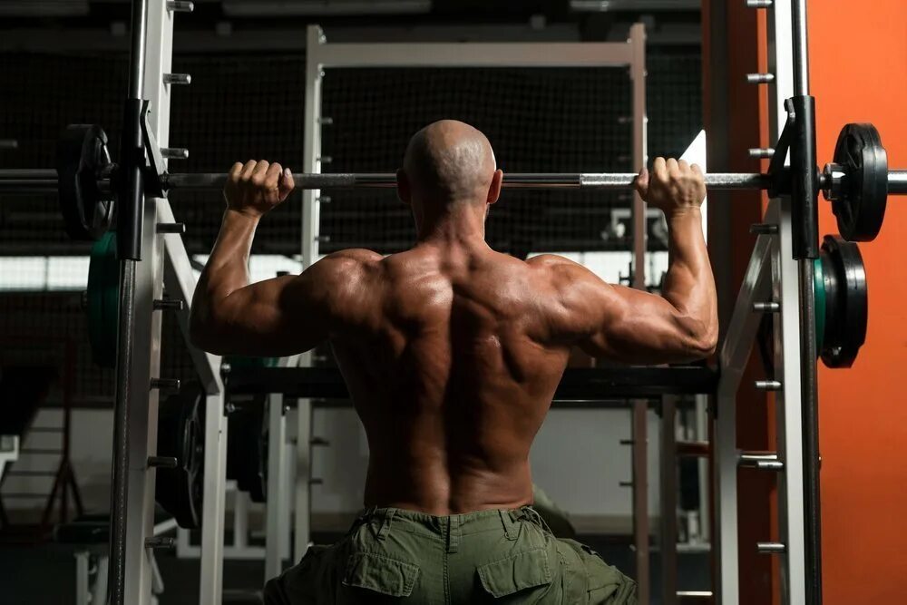 Армейский жим в машине смита. Жим штанги сидя в тренажере смита. Жим в смите на плечи. Армейский жим в тренажере смита. Жим сидя в тренажере смита на плечи.