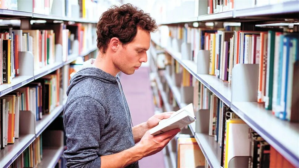 Читать литературные. Читатели в библиотеке. Люди в библиотеке. Книга человек. Мужчина в библиотеке.