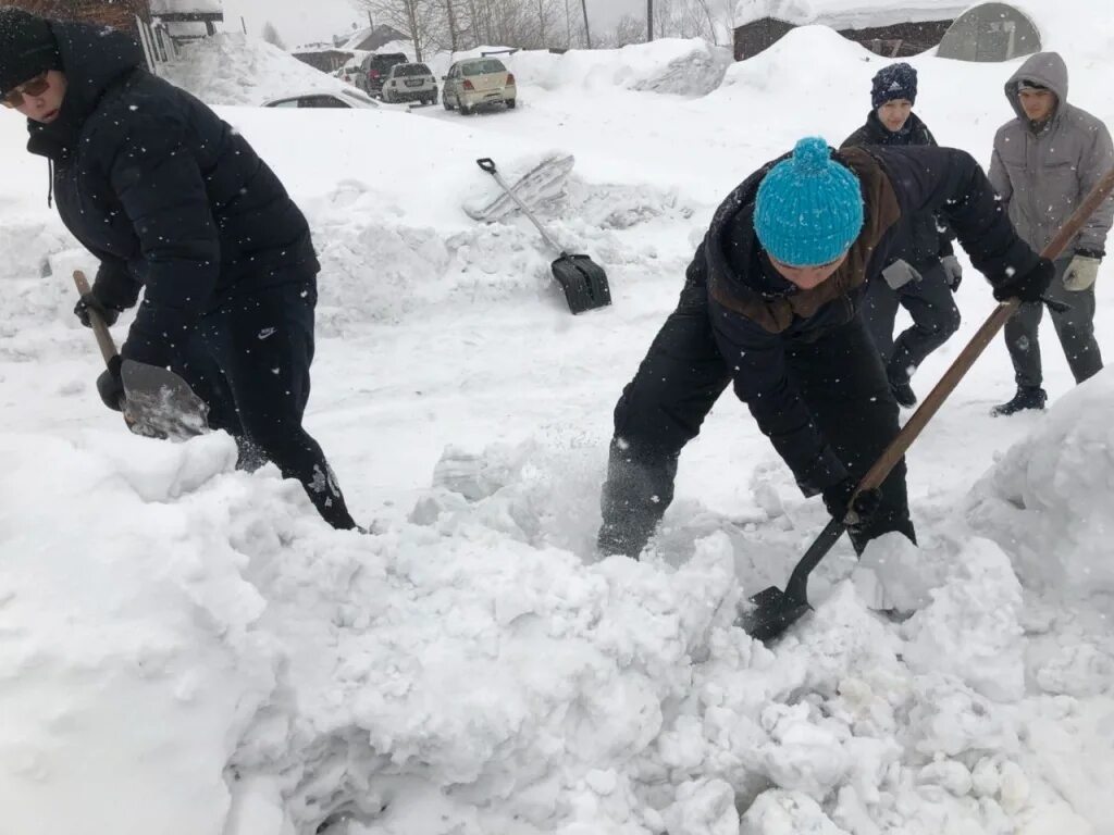 Начинать грозить. Уборка снега волонтерами. Расчищение снега. Дети чистят снег. Человек чистит снег.