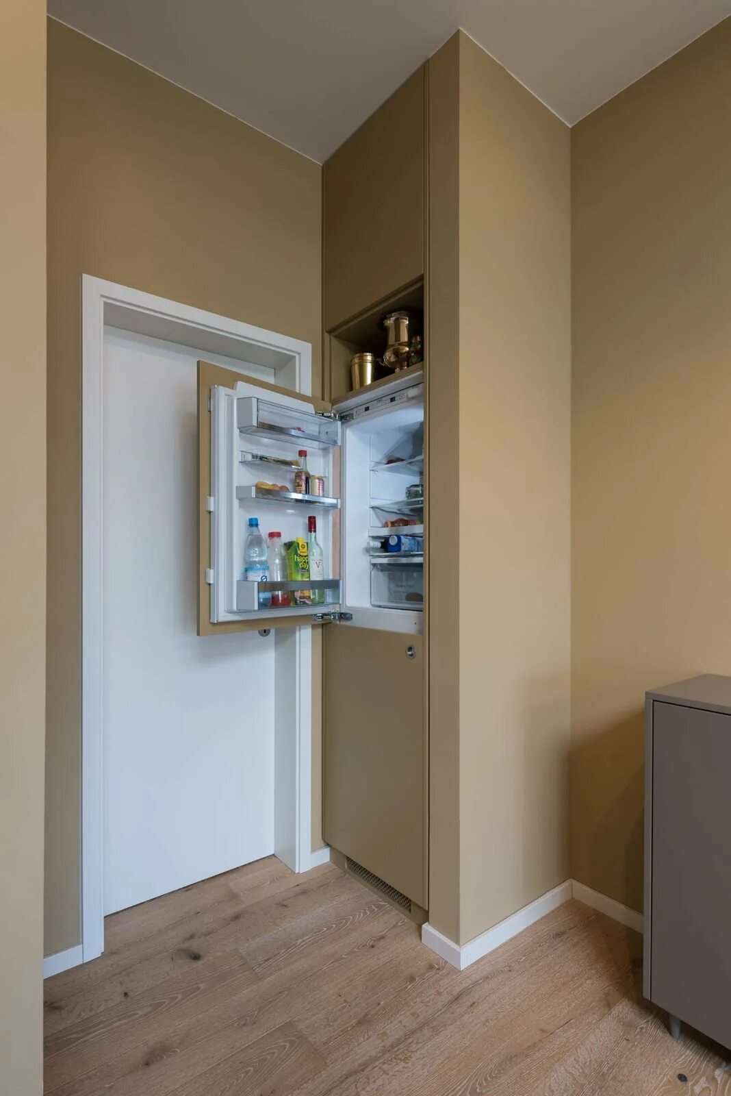 Как можно закрыть холодильник. Холодильник встроенный в нишу. Ниша для встраиваемого холодильника. Встроенный холодильник у стены. Холодильник в нише в коридоре.