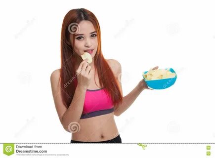 Photo about Beautiful Asian healthy girl eat potato chips isolated on white...