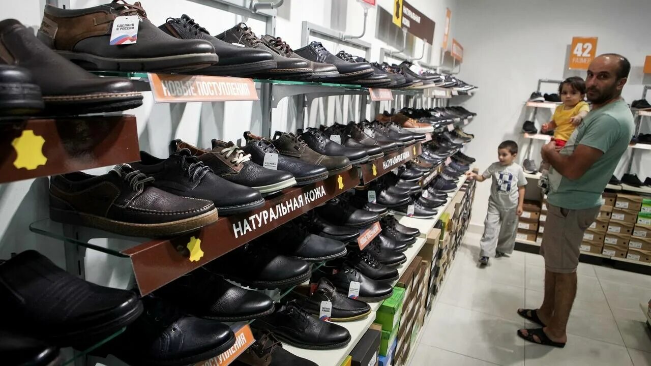 обувь на прилавке. магазин мужской обуви. магазин мужских ботинок. магазин мужских ботинок. обувной бутик мужская.