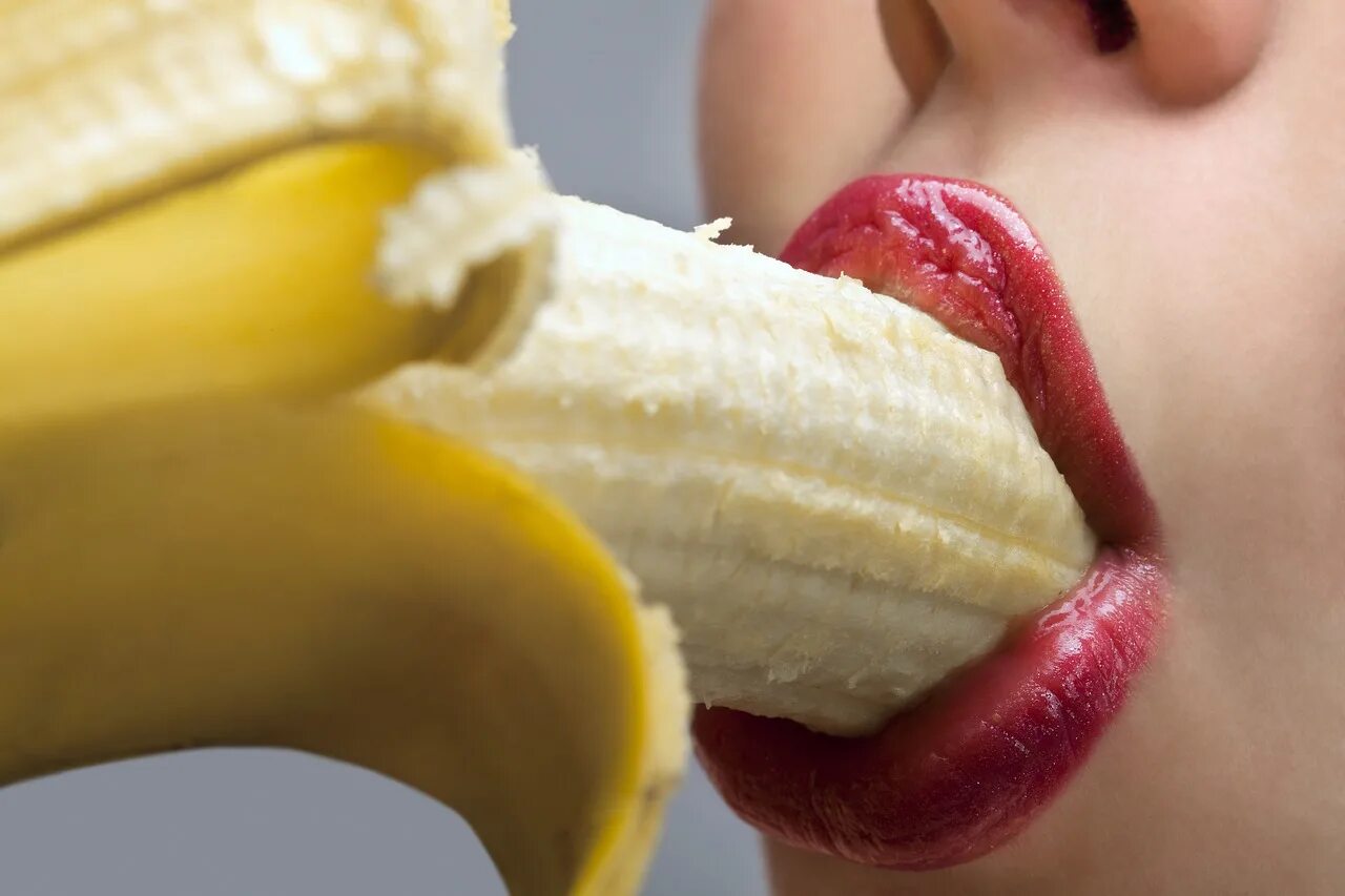 Красиво лижет языком. Губы и банан. Девушка с бананом. Девушка облизывает банан. Девушка кушает банан.