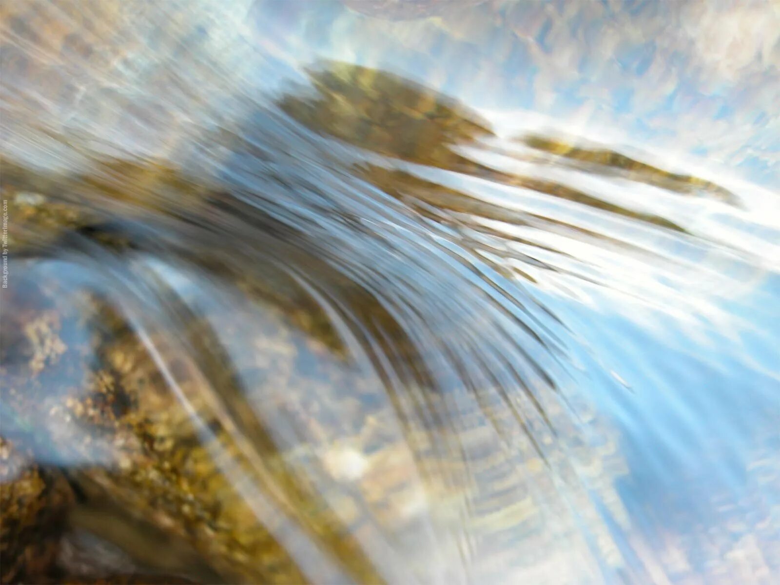 Шлейф воды. Текущая вода. Текучие воды. Солнце сквозь воду. Вода обтекает камень.