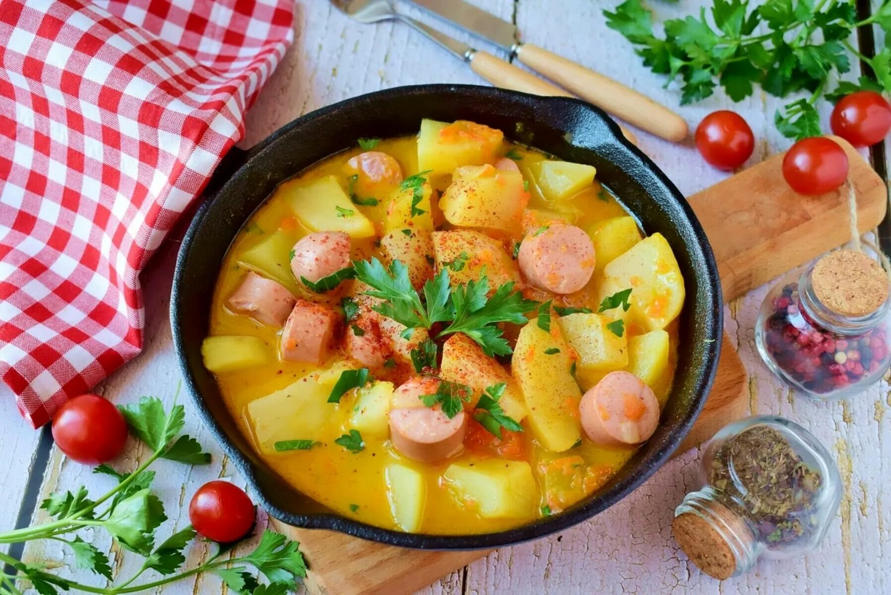 Тушеный картофель с овощами в кастрюле. Тушёная картошка с сосисками. тушеная картошка с овощами. картошка с сосисками на сковороде. жареная картошка с сосисками.