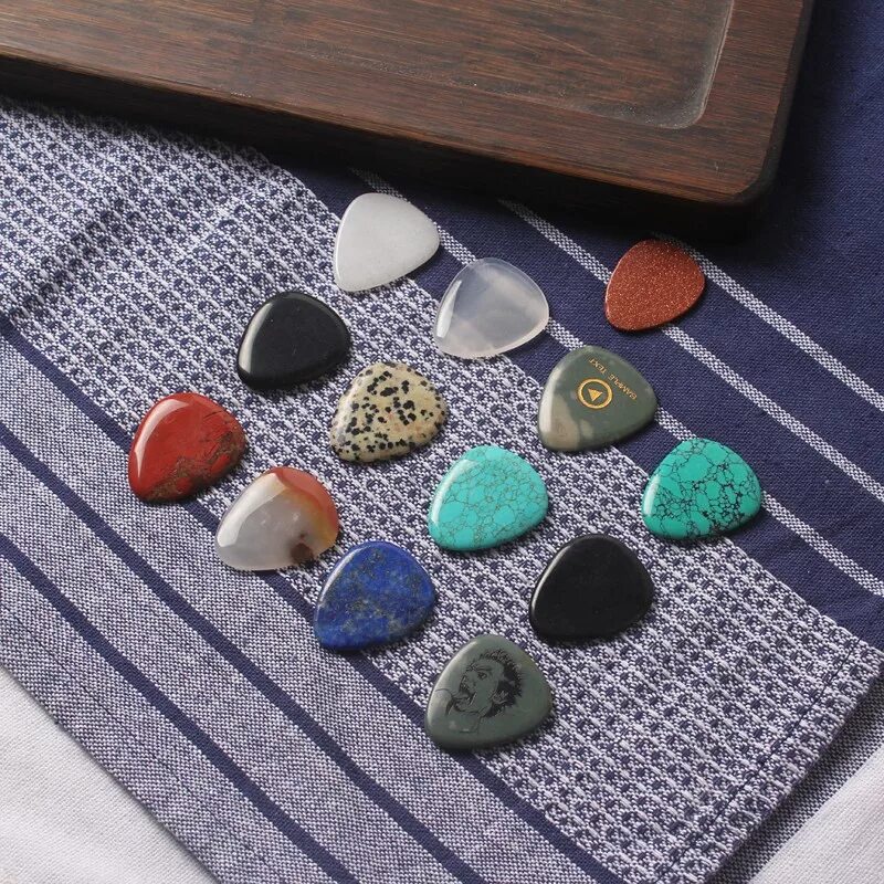 Медиатор из камня. Камешек для гитары. Гитара из камня. Гитара на камне. Caparison.