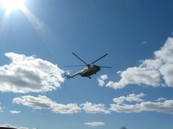 Вертолет летит. Вертолет в небе. Вертолет над землей. Вертолет низко.