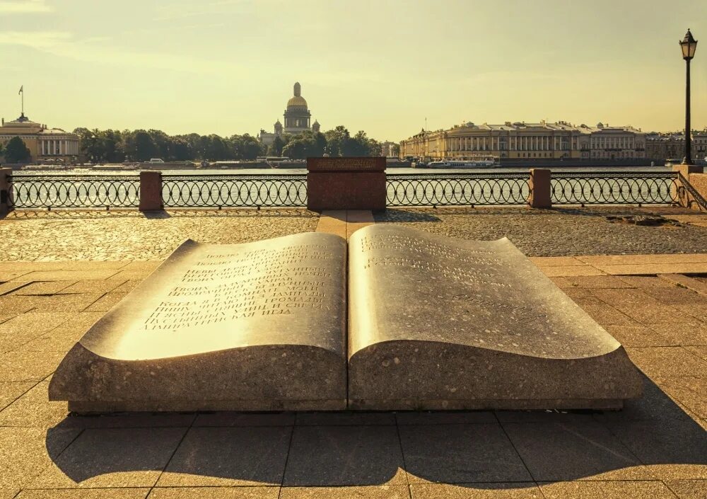 Книги через века. Памятник книге на Университетской набережной Санкт-Петербурга. СПБ Университетская набережная книга памятник. Книга на набережной в Санкт-Петербурге. Памятник раскрытая книга в Санкт-Петербурге.