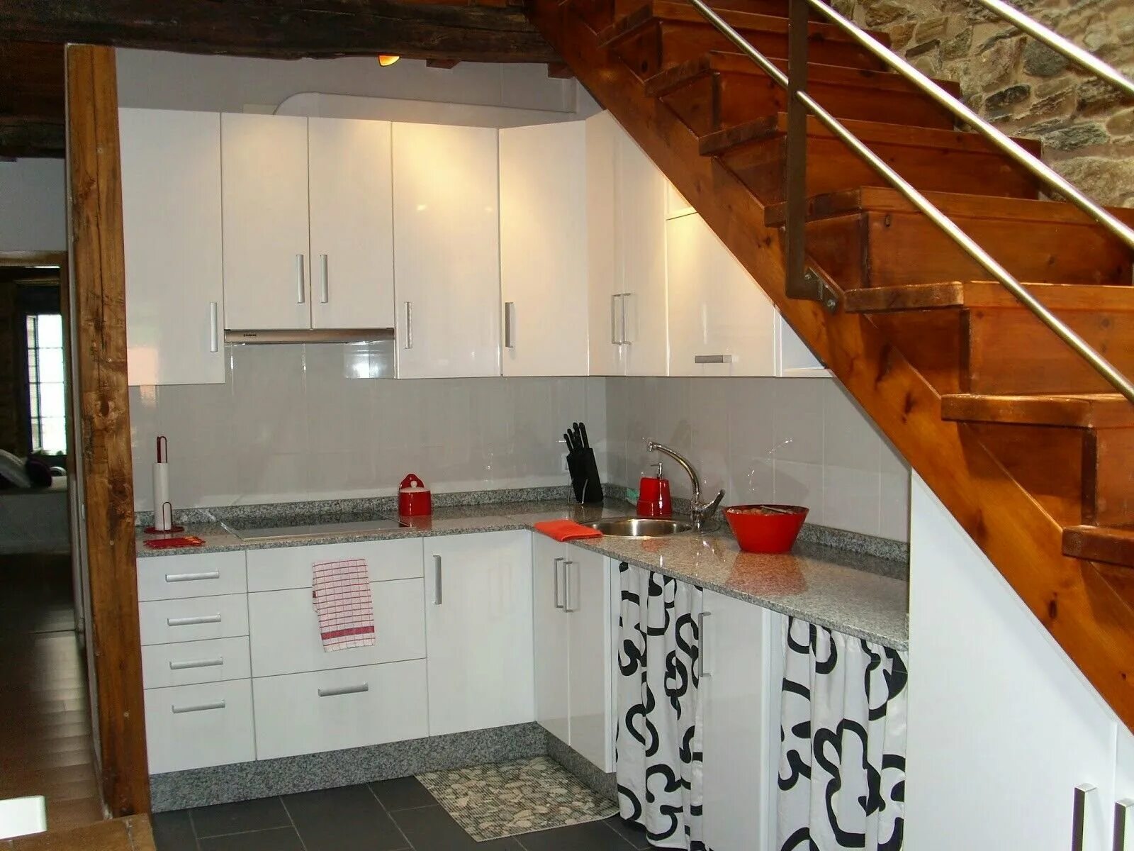 Кухня на первом этаже. Кухня под лестницей. Кухонный гарнитур под лестницей. Угловая кухня под лестницей. Лестница на кухне в частном доме.