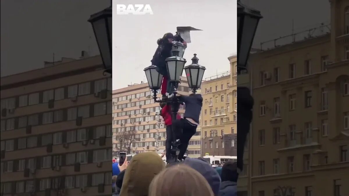 Человек паук на фонарном столбе. Навальный парень на столбе. Митинг парень