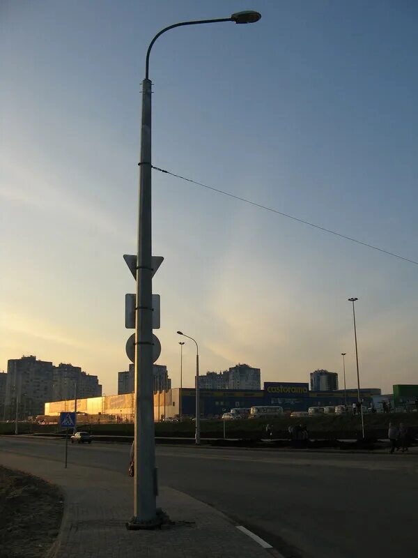 стороны дороги стоят столбы. фонарный столб на улице.