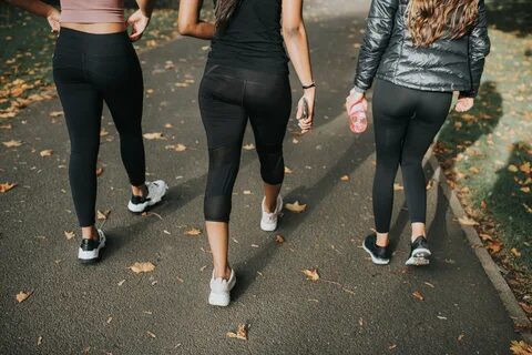 Three women wearing leggings walking down a pathway. 