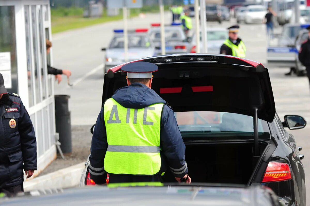 Досмотр гибдд. Досмотр автомобиля. Гаишник осматривает машину. Обыск транспортного средства. Полиция досмотр авто.