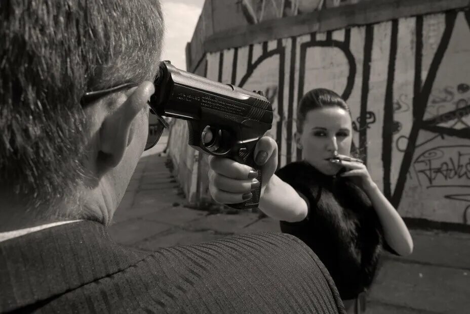 Хороший угрожать. Мужчина и женщина с пистолетами. Женщина с пистолетом. Мужчина целится в женщину.
