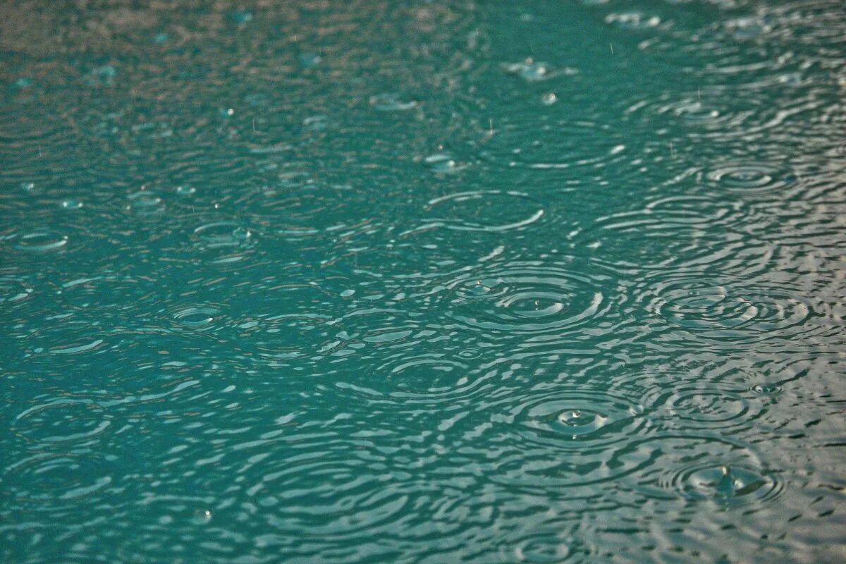 Капли дождя на воде. Дождевая вода. Круги на воде дождь. Бирюзовая поверхность.