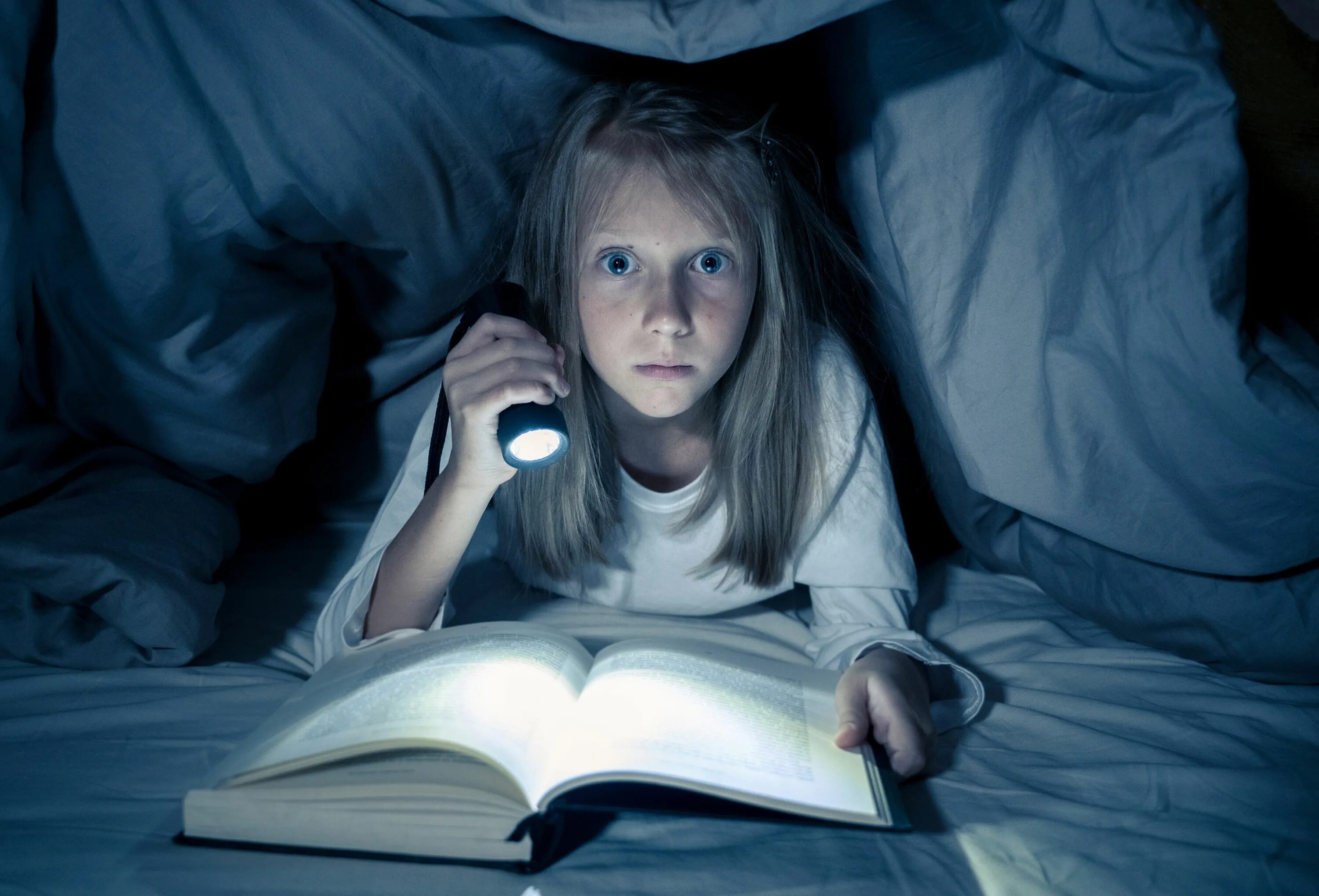 Чтение под одеялом с фонариком. Девушка читает страшную книгу. Девочка под одеялом с фонариком. Девочка с книгой подоодеялом. Scary read