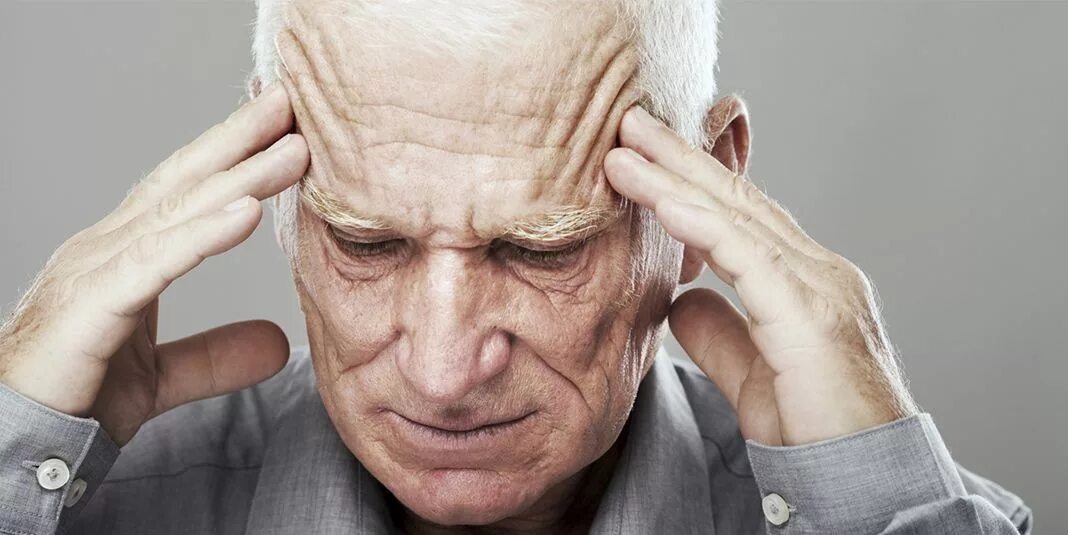Старческое лицо. Старик болит голова. Головная боль у пожилого. Старик держится за голову. Головной микроинсульт
