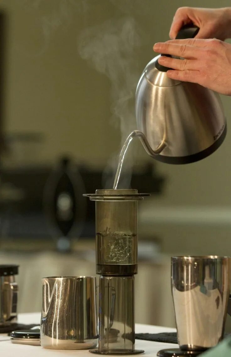 Кипящее кофе. Горячая вода в стакане. Вода из чайника. Приготовление кофе. Стакан для готовки кофе.
