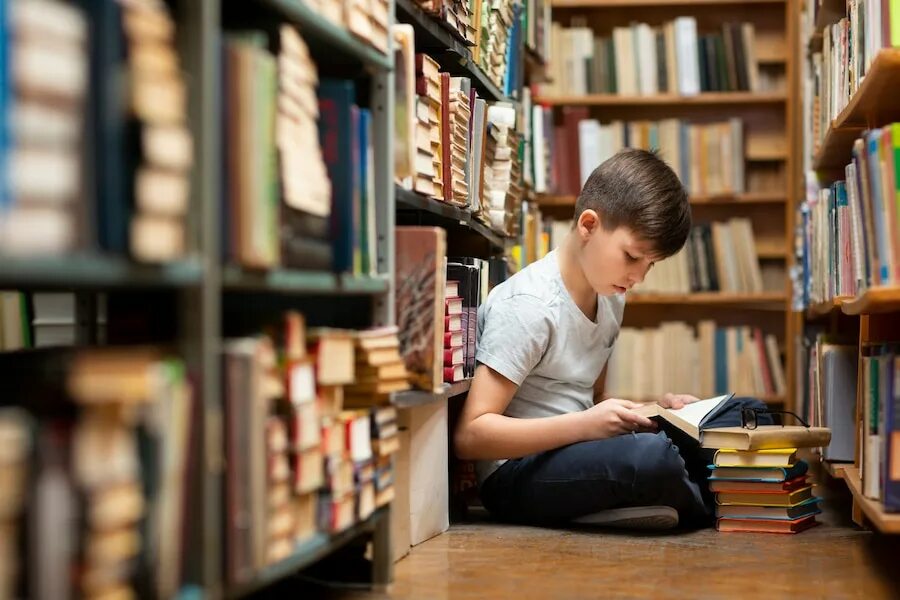 Мальчик в библиотеке. Юноша в библиотеке. Дети в библиотеке. Чтение книг.