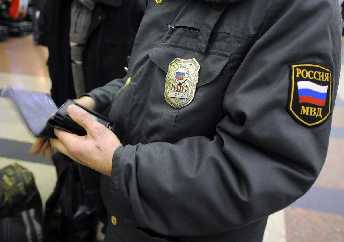 Полицейский проверяет телефон. Сотрудник полиции проверяет документы. Полицейский проверяет телефон. Полицейский проверяет. Милиционер проверяет документы.