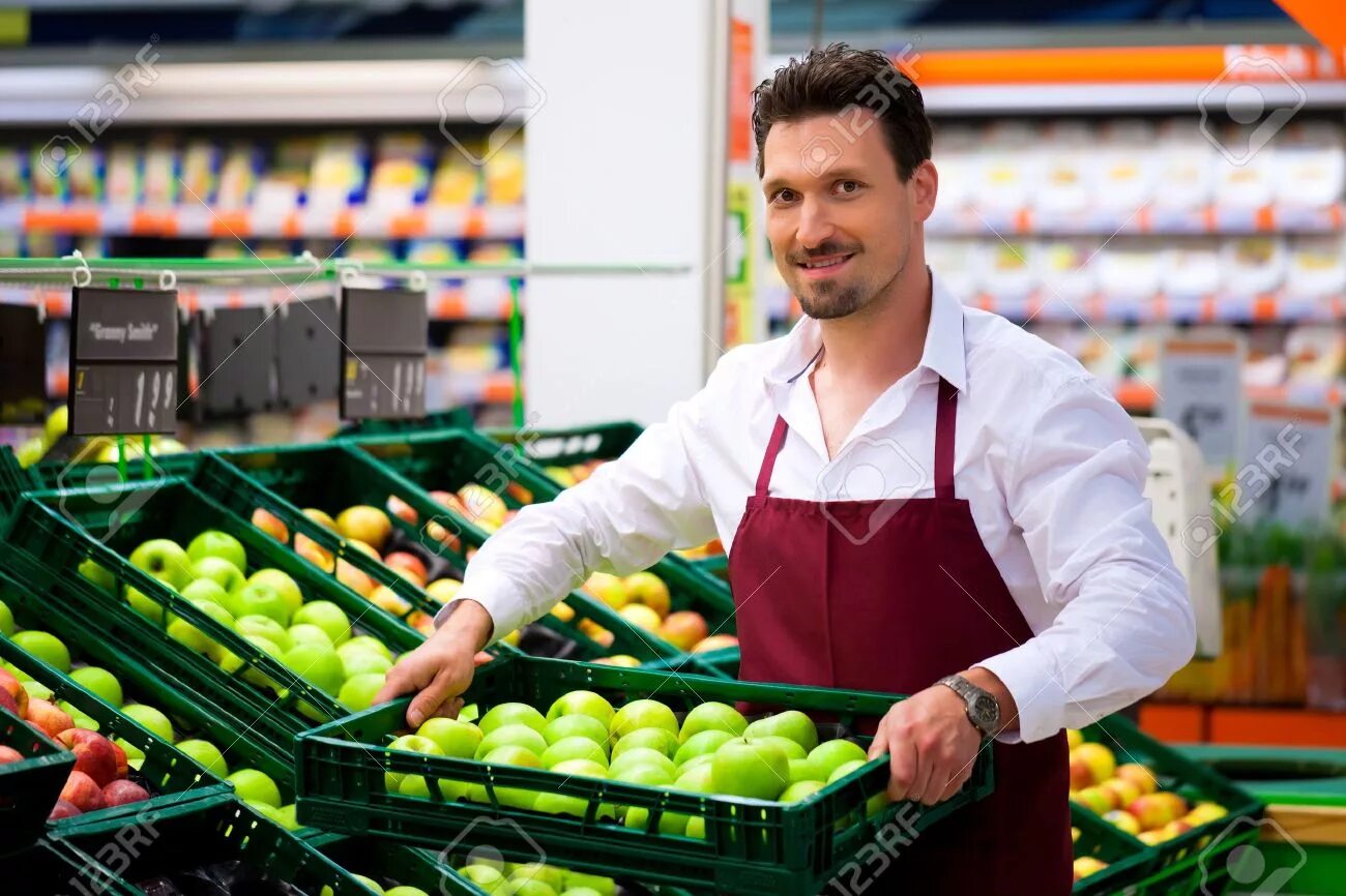 He work in a shop. Продавец овощей и фруктов. Работник супермаркета. Продавец в супермаркете. Продавец овощи фрукты.