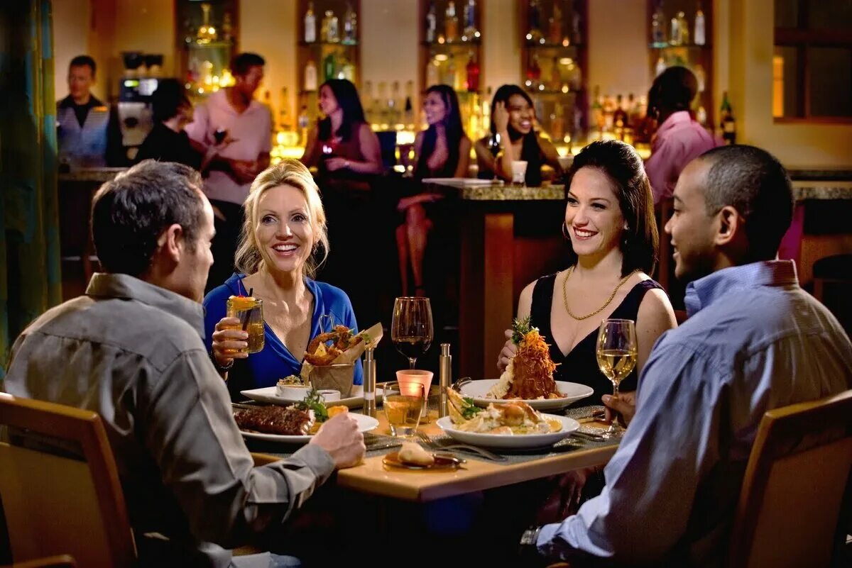 Люди за столом в ресторане. Люди за столиками в ресторане. Ресторан с посетителями. Беседа за столом.
