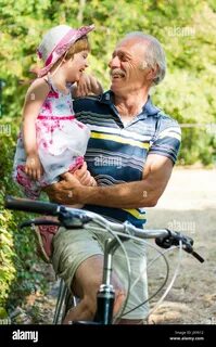 Grandpa laughing on bicycle with his granddaughter Stock Photohttps. heart_...