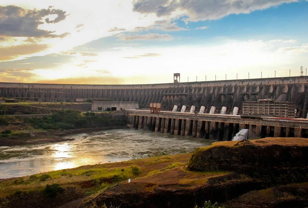 Люди перегородили реку большой плотиной вода выше. Плотина Итайпу в Бразилии. Плотина Итайпу в Парагвай. Плотина гидроэлектростанции Итайпу. ГЭС «Итайпу», Бразилия и Парагвай.