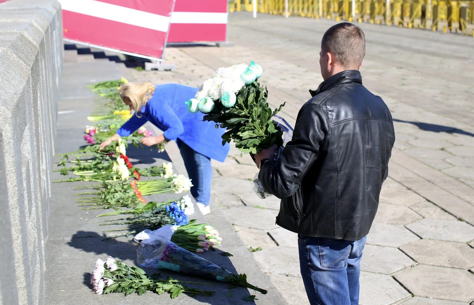 В риге запретили нести цветы. Несут цветы к памятнику. Рига 9 мая 2022 цветы у памятника. Цветы памяти. Выброшенные цветы.