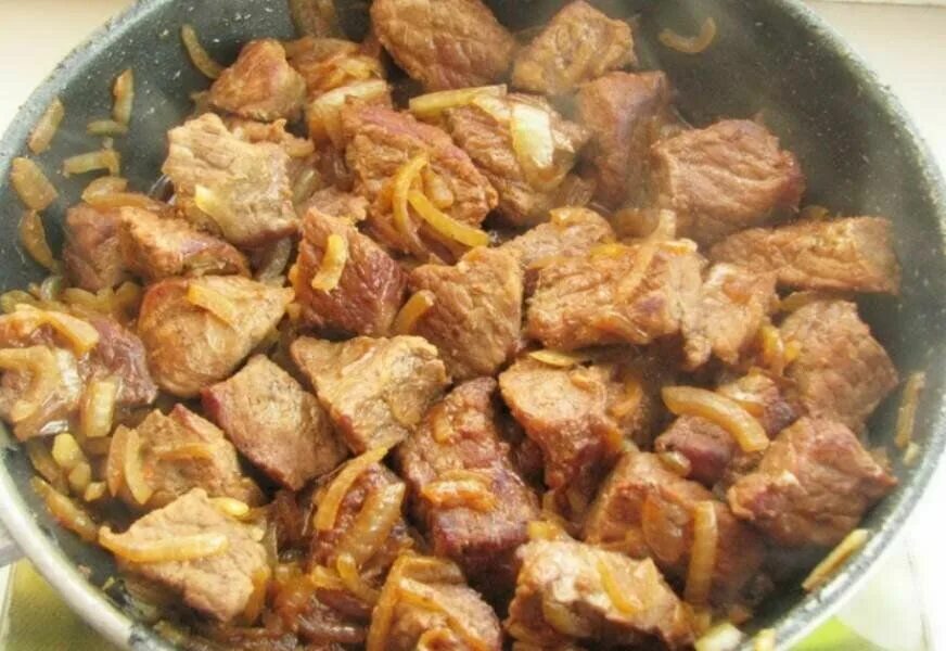 Печень говяжья жареная. Говядина по азиатски. Жареное мясо с луком на сковородке. Жареная свинина на сковороде с луком. Жареная говяжья печень с луком подача.