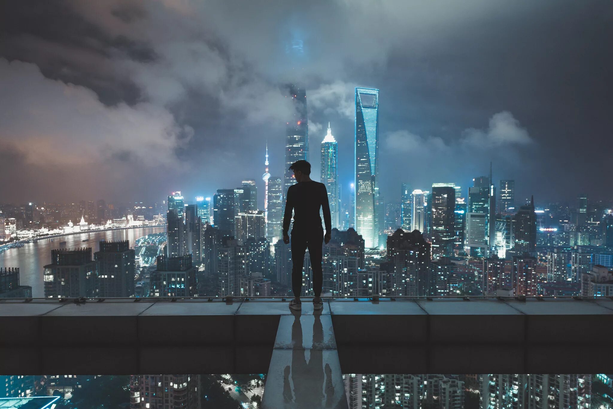 Человек стоит над городом. Шанхай небоскребы. Крыша небоскреба. Человек на небоскребе. Человек на фоне ночного города.
