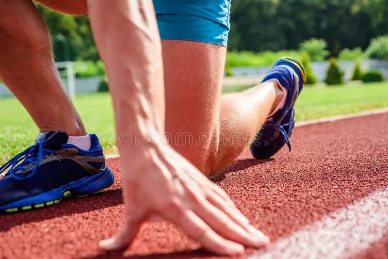 Кроссовки готовящихся к старту спортсменов. Фото руки бегуна на старте. Sportmen on start. Running position. Ready to run