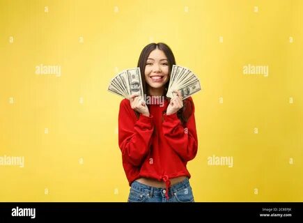 Closeup of young beautiful woman with us dollar money in hand over yellow b...