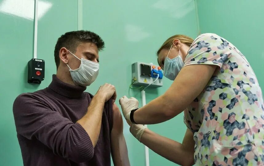 Больница прививка. Человек в маске после вакцины. Прививки в больнице. Врач делает прививку.
