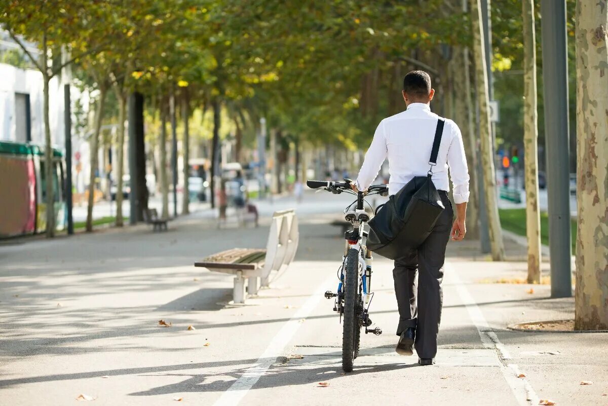 Ездить на работу на велосипеде. Люди на велосипедах в городе. Бизнесмен на велосипеде. Человек ведет велосипед. Прогулка на велосипеде.
