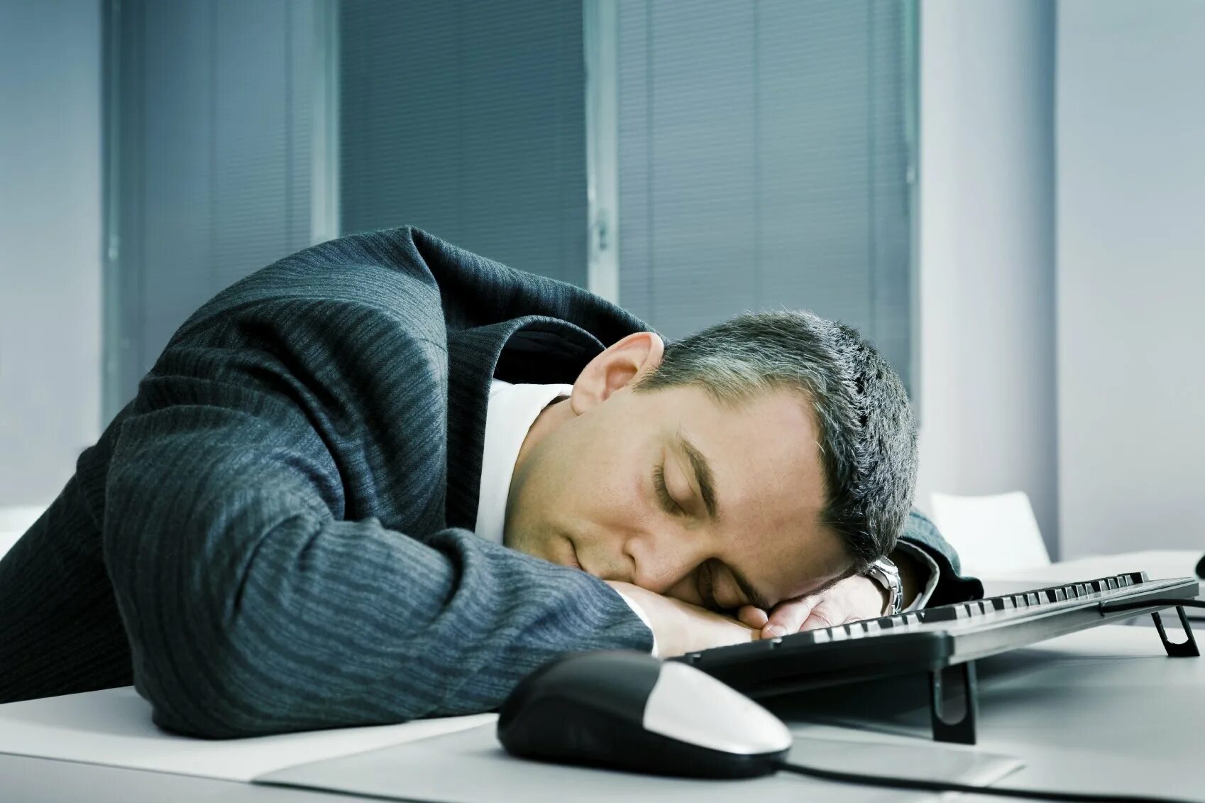 Мужчина на день работа. Уставший мужчина. Усталый бизнесмен. Спит на рабочем месте. Сонный человек на работе.