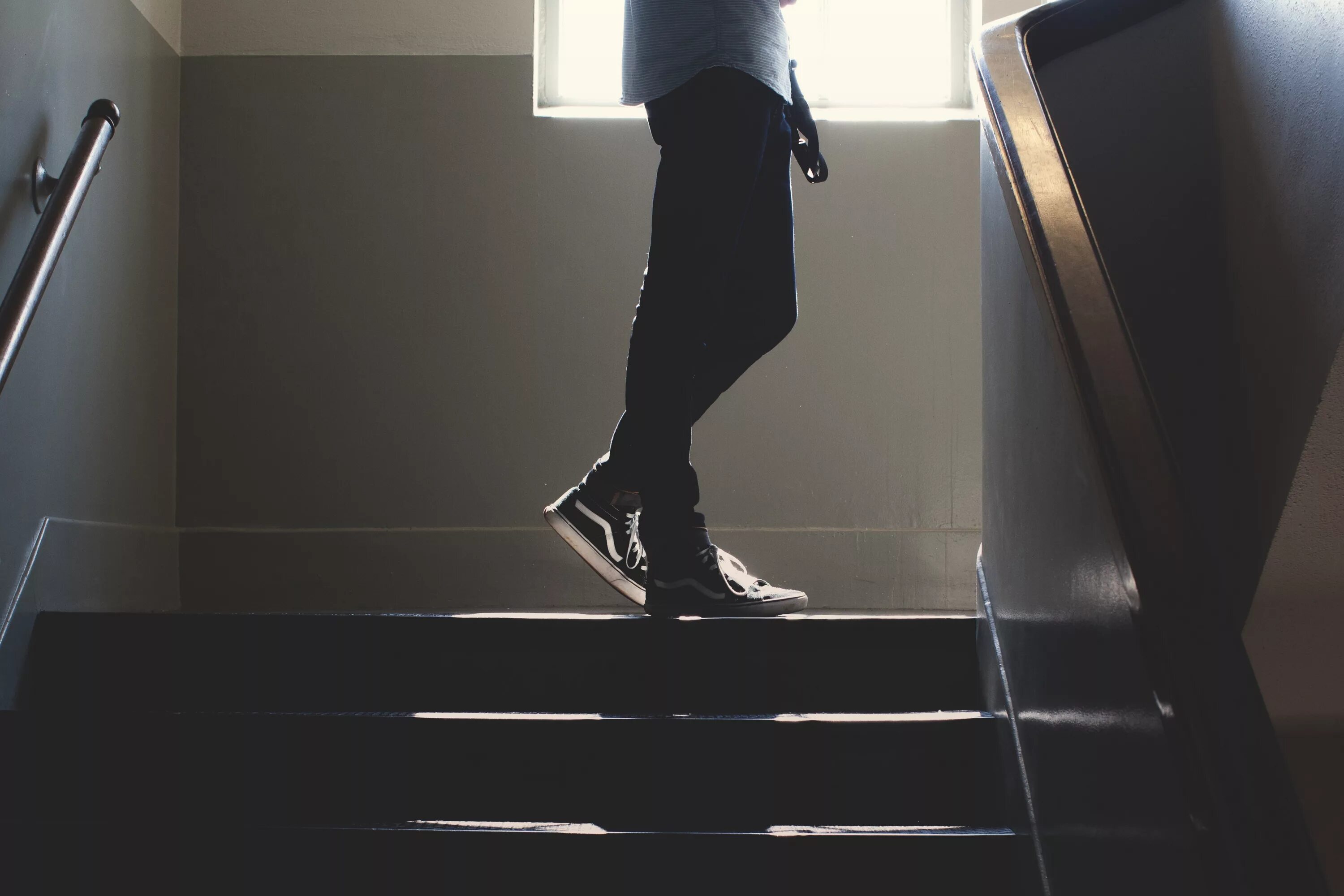 Мужчина поднимается по лестнице. Поднимается по лестнице. Парень на лестнице. Человек поднимается по лестнице. Поднимается по ступенькам.