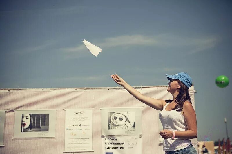 Самолет бумажный теперь уже не важно. Фотосессия с бумажными самолетиками. Девушка запускает самолетик. Запускает бумажный самолетик. Девушка с бумажным самолетиком.