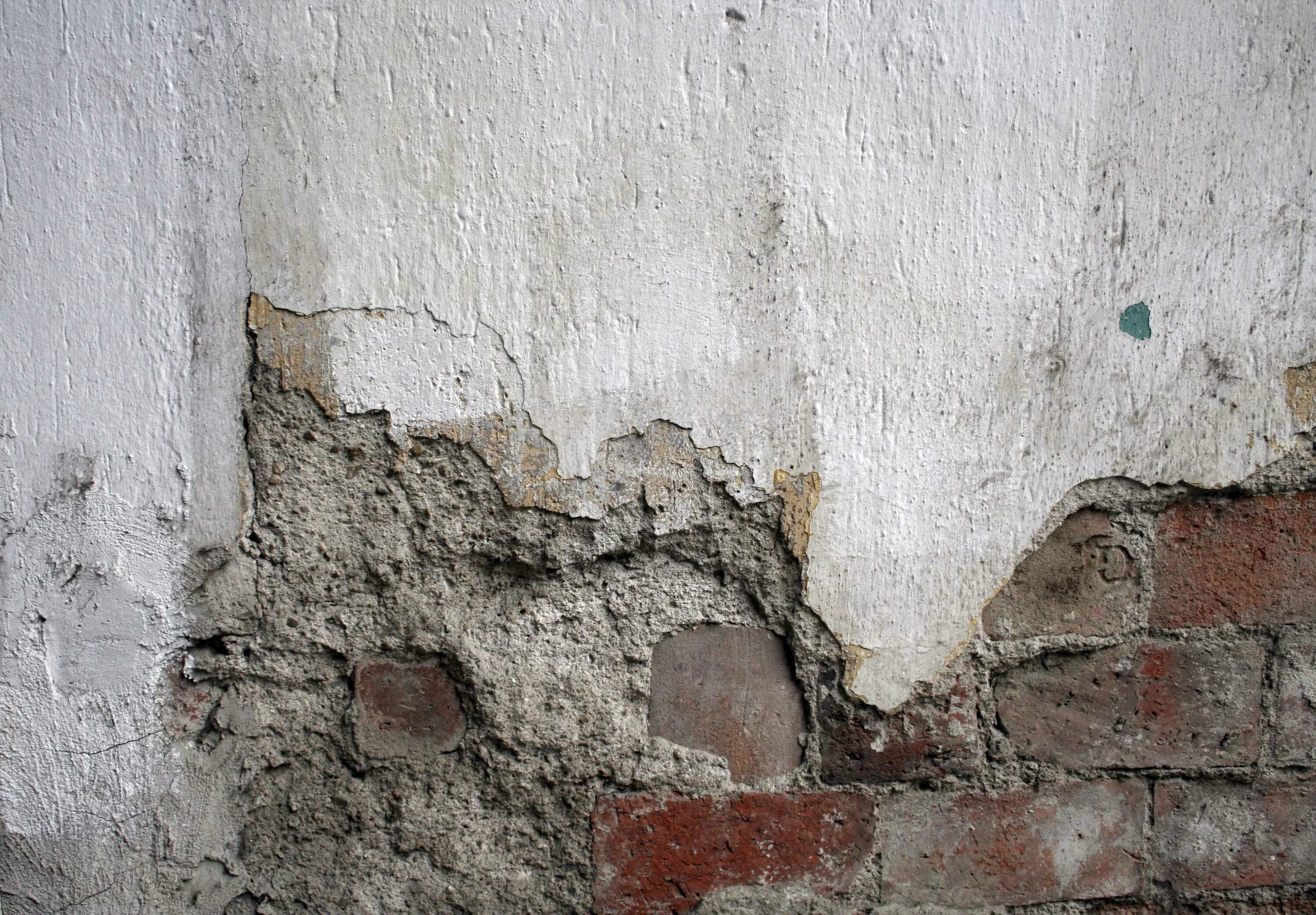 Трещины в перегородках. Старая штукатурка. Разрушение штукатурного слоя. Бетонная стена. Трещины в стенах здания.