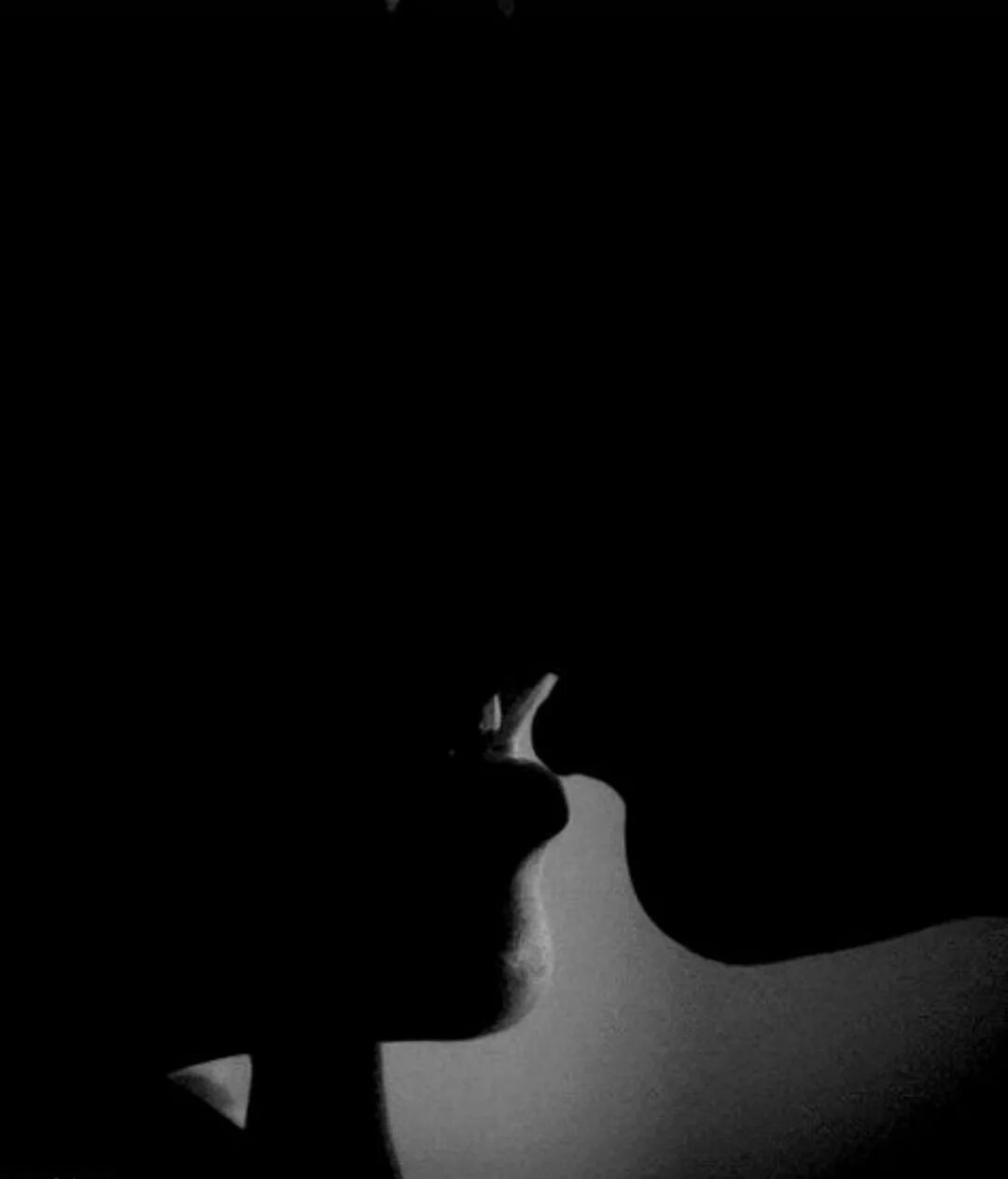 Черный и белый лбов. Нежный поцелуй в темноте. Страстный поцелуй в темноте. Мужчина и женщина в темноте. Пара в темноте.