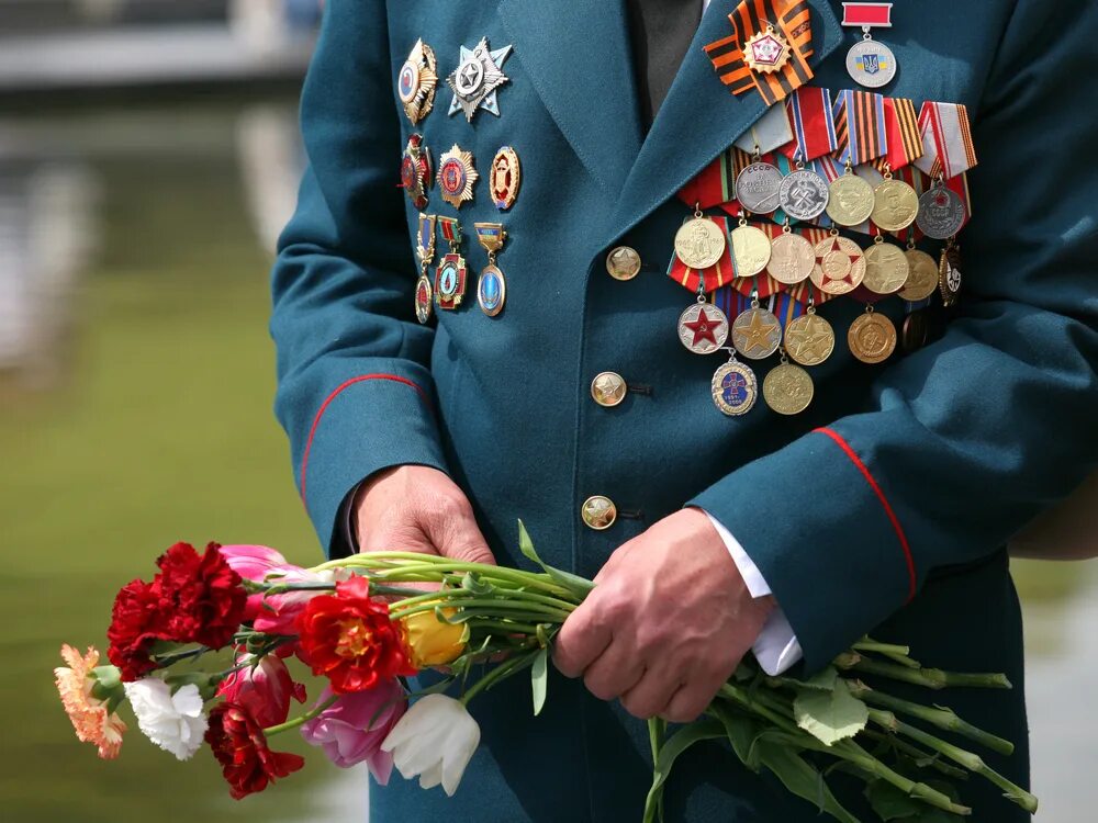 Выплаты детям войны ко дню победы. День Победы ветераны. Ветераны с цветами. Ветеран с гвоздиками. Ветераны с орденами.