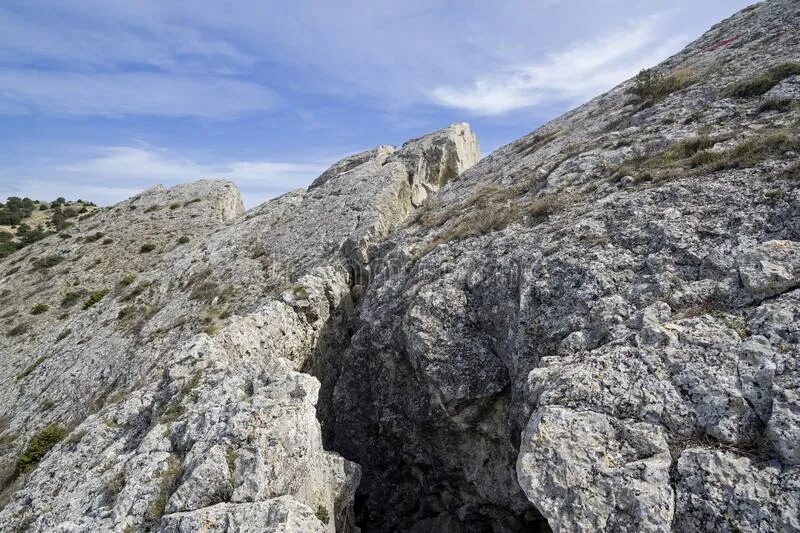 Отвесная скала Крым. Глубокая трещина в скале. Глубокие трещины в горах. Гора раскололась.