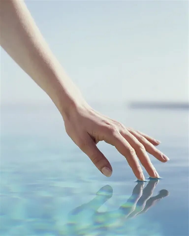 Рука касается воды. Вода в руках. Красивые руки. Ладонь касается воды. Включи руки вода