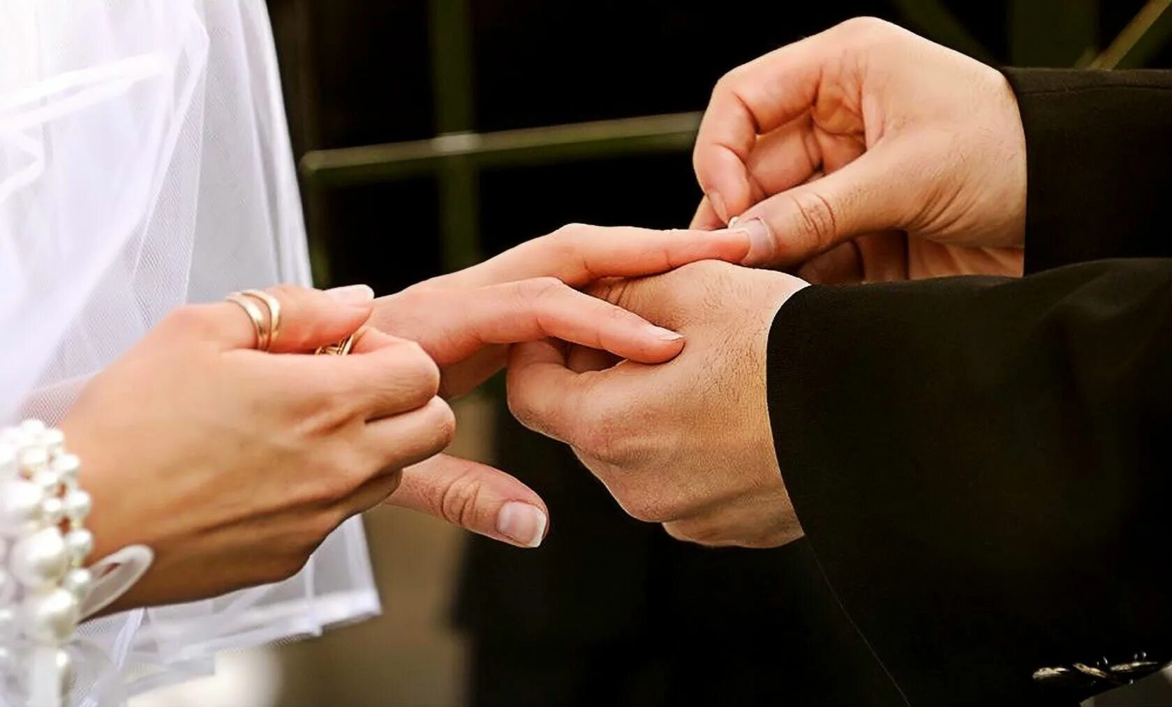 Кольцо замужества. Свадебные кольца на руках. Жених одевает кольцо невесте. Свадьба руки с кольцами. Свадебные кольца в ЗАГСЕ.