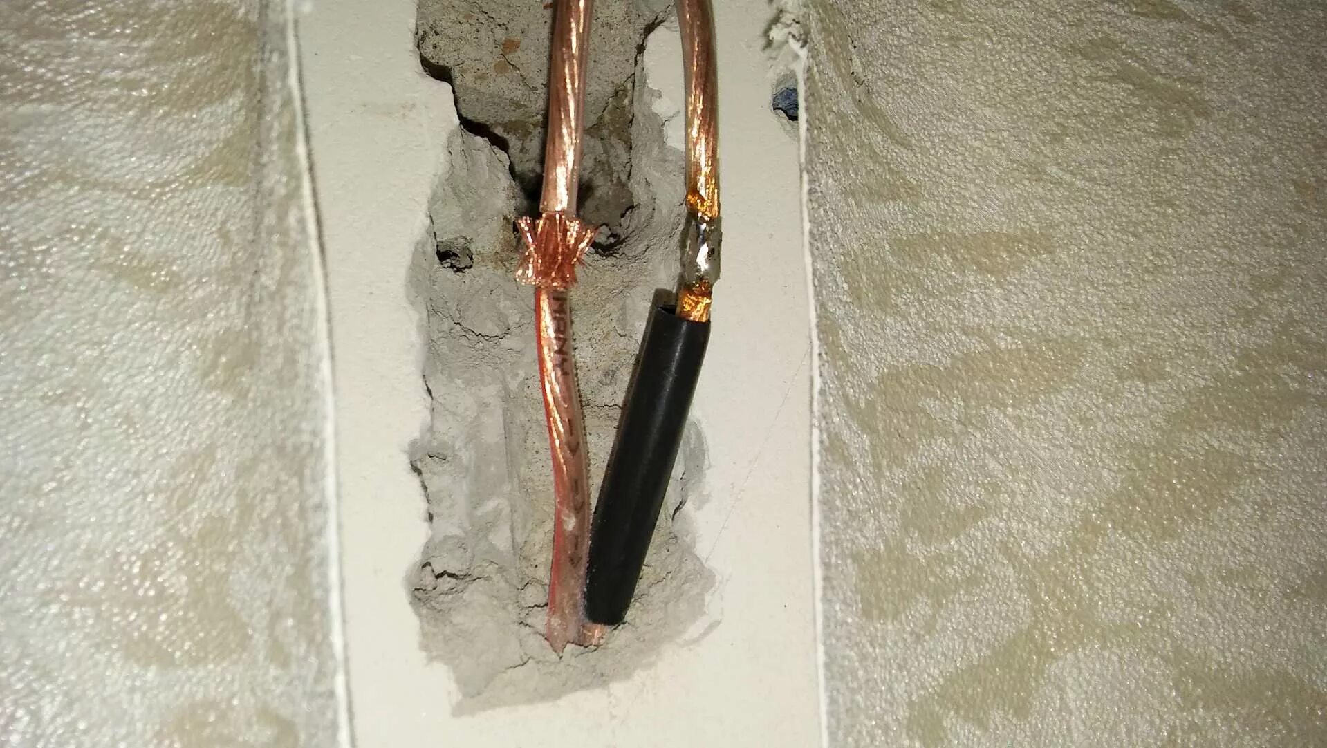 пробит кабель в стене. провода на стене. провода на стене. соединение проводов в стене. поврежденная изоляция провода.