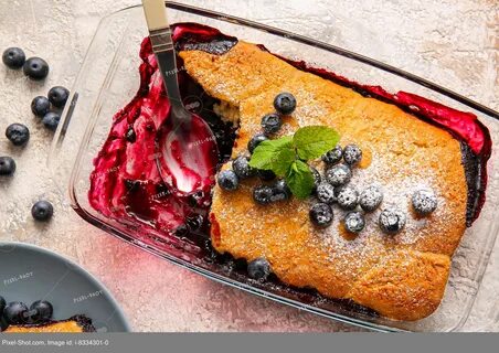 Baking dish with blueberry cobbler on light background. 