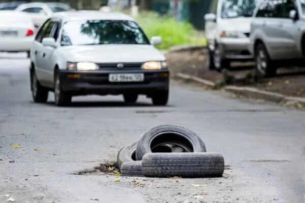 Колесо попало в яму на дороге. Колесо в яме. Машина попала в яму на дороге.