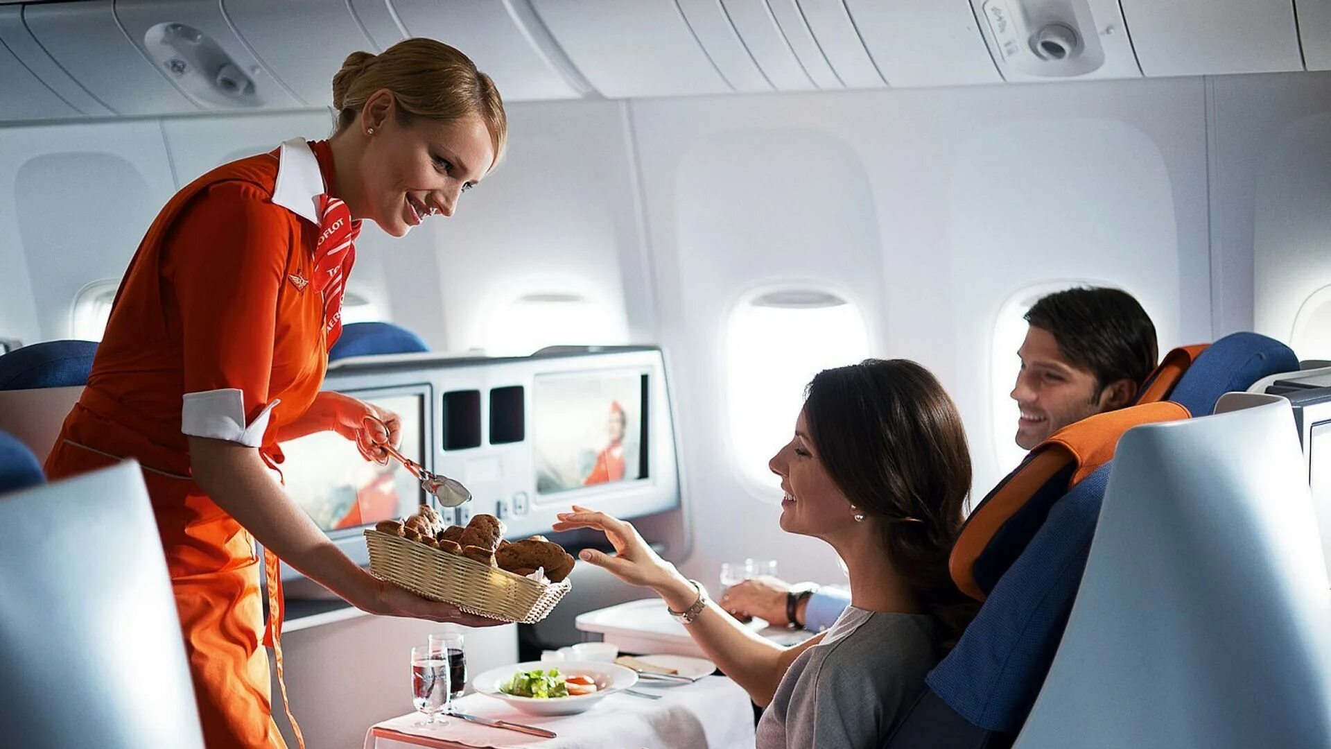 Еда в самолете. Борт самолета. Пассажиры на борту самолета. Стюардесса с едой.