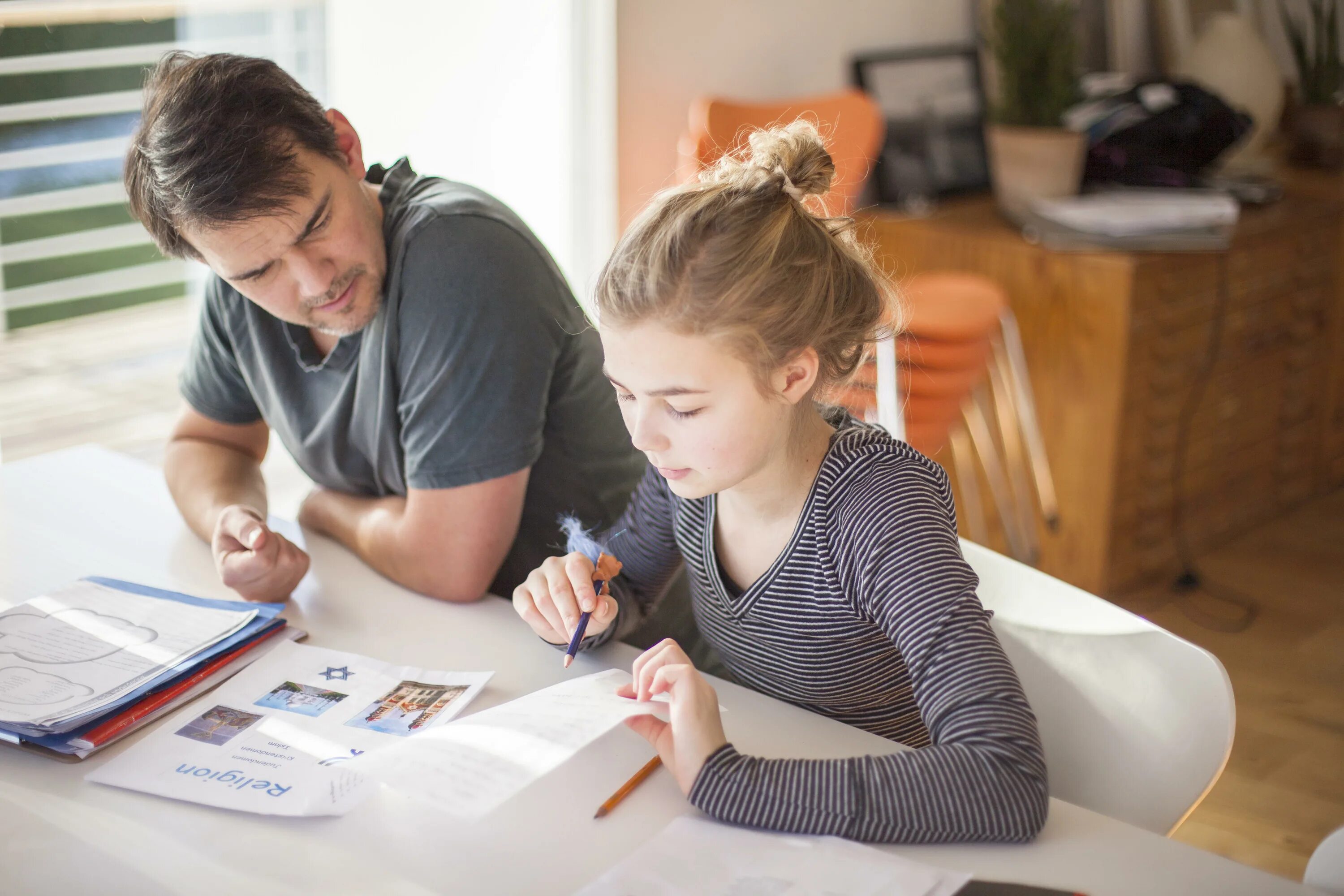Doing their homework. Children do homework. parents and children at home doing homework. parents&#039; role. the kids are doing their homework..