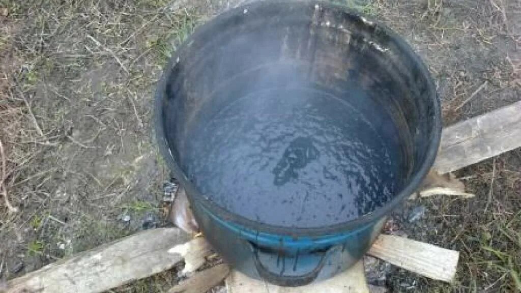 Битум варка. Ведро для разогрева битума. расплавленный битум. разогрев битумной мастики на костре. ведро гудрона.